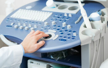 Sonographer using ultrasound machine at work. Sonographer using ultrasound machine at work. Modern medical device for human body visual diagnostics. Close-up male hand at ultrasound scanner control panel. Diagnosis and research of diseases.
